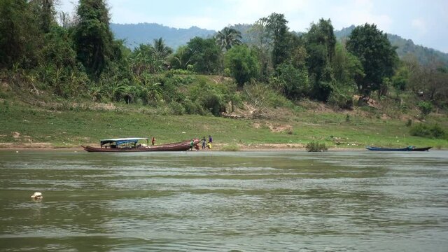 Scenic View Of People Standing By Boat By River - Luang Prabang, Laos