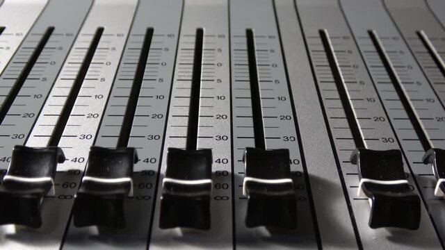 Motorized digital music console faders.