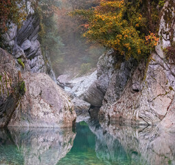 Foggy autumn mountain morning on the river with blue water