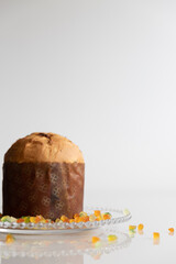 Panettone decorated with candied fruit on the table for Christmas Day. Photo with light background