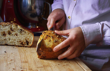 Man cutting fresh homemade organic bread for morning breakfast