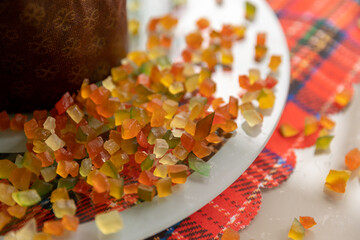 colorful candied fruits next to Panettone on a table decorated on Christmas Day, approximate photo