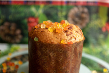 Panettone decorated with candied fruits on the table for Christmas day.