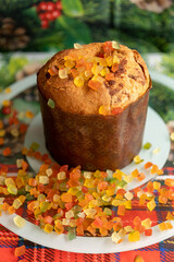 Panettone decorated with candied fruits on the table for Christmas day.