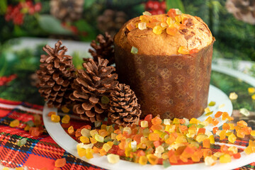Panettone decorated with candied fruits on the table for Christmas day.