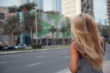 Fototapeta na wymiar Young beautiful blonde woman walk in Dubai downtown. Enjoying travel in United Arabian Emirates. Vacation and sightseeing concept