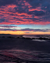 Fototapeta na wymiar Pink purple orange dramatic sunset on the beach at dusk