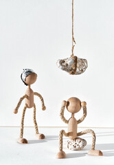 Anxiety against corona virus vaccine, creative concept. Wooden man sitting underneath heavy stone...