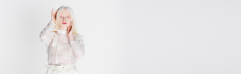 Pretty albino woman holding hands near head isolated on white, banner.