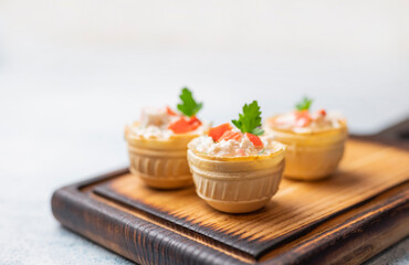 tartlets with Olivier salad with crab sticks and filling on a festive table