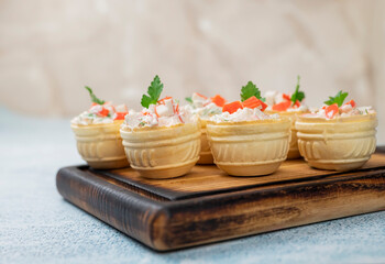 tartlets with Olivier salad with crab sticks and filling on a festive table
