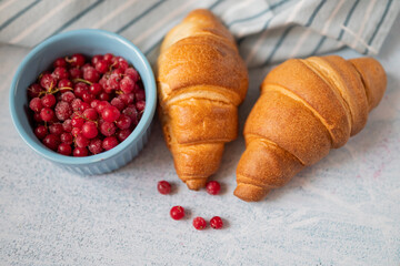 delicious sweet pastry croissant with red currant berry for breakfast