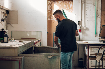 Male worker preparing screen printing film in workshop