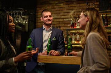 Cheerful colleagues drinking beer in the bar together after work