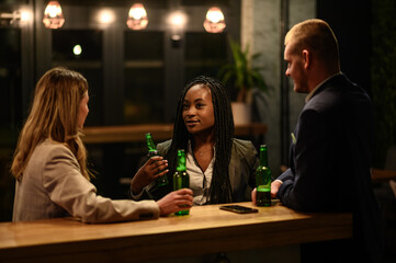 Cheerful colleagues drinking beer in the bar together after work