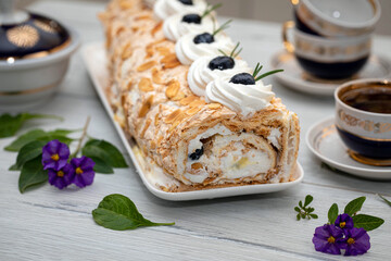 Bizet roll with whipped cream, garnished with nuts and berries.