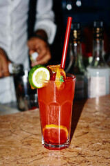 Red drink with strawberry lime ice. Bartendeer prepared cocktail with campari aperol gin