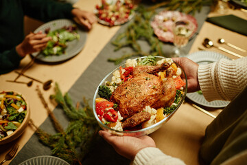 Top view close up of African-American woman bringing food to table while celebrating Thanksgiving with family