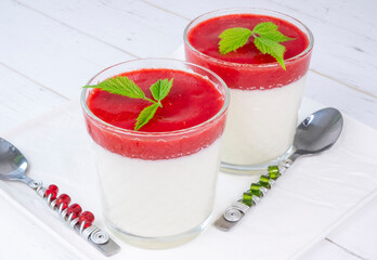 pana cotta in glasses with strawberry sauce on a white background