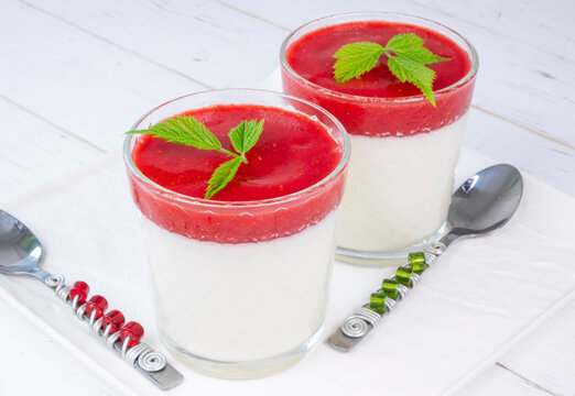 pana cotta in glasses with strawberry sauce on a white background