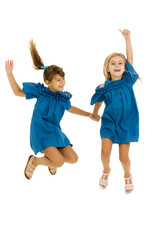 Two happy girls jumping holding hands