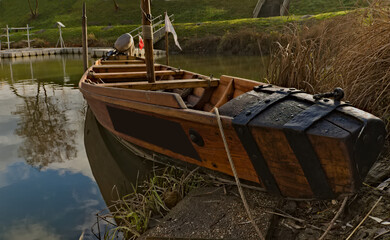 At the marina . Drewniana łódź ( barkas , czółno ) zacumowana przy nabrzeżu .   Wooden boat (Canoe) moored by the waterfront . - obrazy, fototapety, plakaty