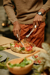 Vertical close up of unrecognizable African-American man serving chicken while enjoying dinner with family