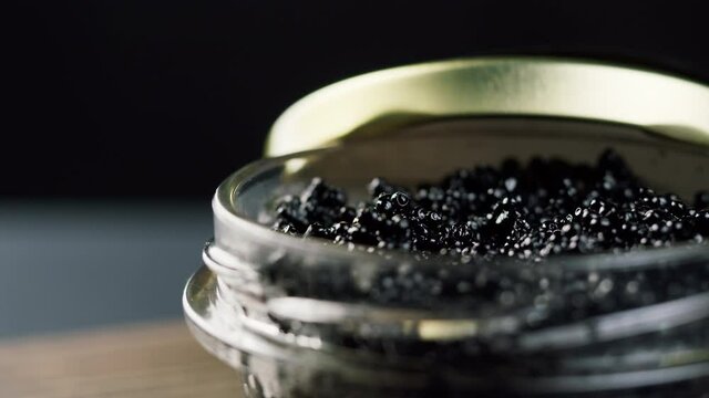 Black caviar close-up. Beluga sturgeon salted roe in glass bowl. Raw seafood. Luxury delicacy food. Delicious and tasty fish products. Russian cuisine. Festive dinner.