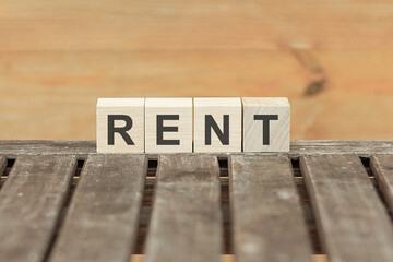 Rent concept with wooden block on wooden table background