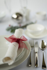 Festlich gedeckter Weihnachtsschmuck-Tisch in elegantem Weiß-rot im Hochformat