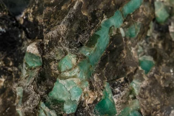 Poster Macro emerald stone mineral in rock on white background © Minakryn Ruslan 