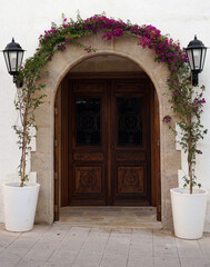 Fototapeta na wymiar an arch of flowers near the door in a building in Spain