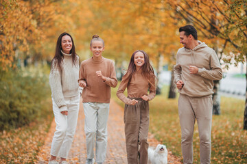 Portrait of happy family of four in autumn day