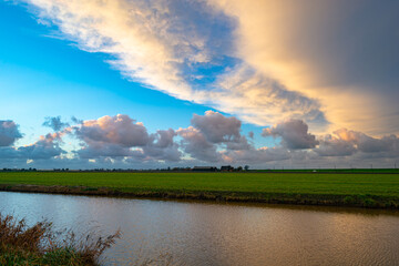 Wide angle view of beautiful sunset clouds over the Dutch polder landscape near Gouda, Holland