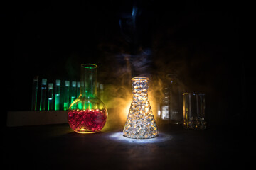 Test glass flask with solution in research laboratory. Science and medical background. Laboratory test tubes on dark toned background , science research equipment concept