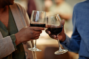 Close up of African-American couple clinking wine glasses while enjoying romantic dinner at home