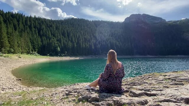 Beauty of nature and person, A girl sitting with Amaizing view on Durmitor lake and mountains, National Park, Mediterranean, Montenegro.