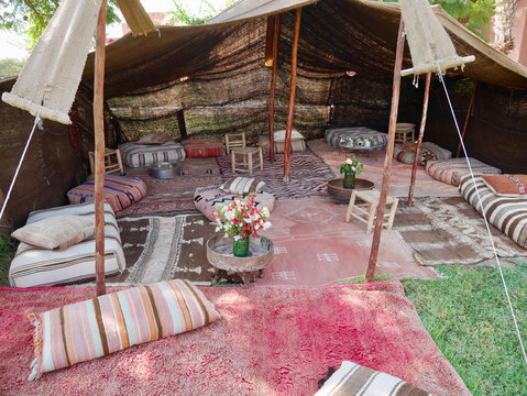 Bedouin tent with cozy pillows and colorful carpets in Marrakech, Morocco.