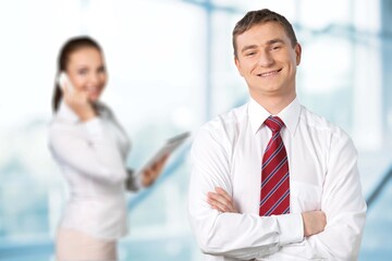 Obraz premium A couple of smiling business people on the office background