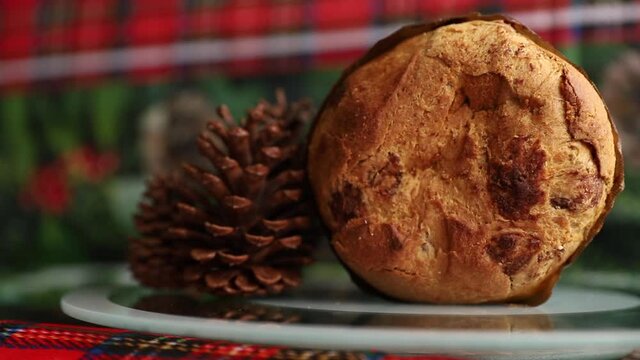 delicious Christmas panettone, with candied fruit. Panettone rotating decorated with Christmas pine cones. chocotone, christmas cookies with nuts