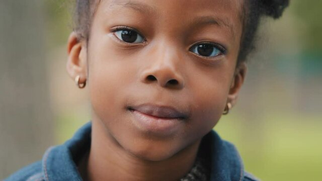 Portrait child showing tongue close-up face cute little girl african american playful kid outdoors mischievous schoolgirl looking at camera careless childhood fun spend time cheerful beautiful preteen