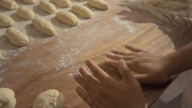 man's hands making pieces of bread