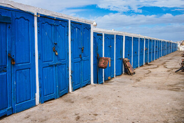 Naklejka premium Blue wooden doors of the huts in the fishing port of Essaouira, Morocco