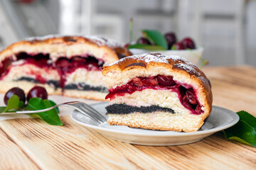 Piece of cherry pie on plate on rustic wooden board with full cake and sweet cherry berries on background. Easy recipe of berry dessert for everyday cooking. Homemade bakery by classic recipe.