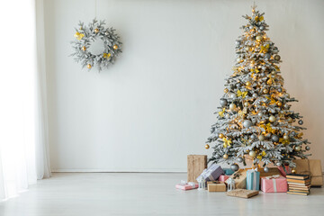 white snow-covered Christmas tree with gifts decorations new year