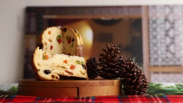 Delicious panettone slice with candied fruit with blurred background. Chocotone. camera movement approaching the panettone