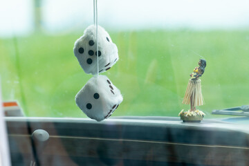 A pair of fuzzy dice hanging from a car's rear-view mirror