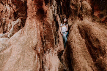 Preteen girl climbing on rocks on a warm day