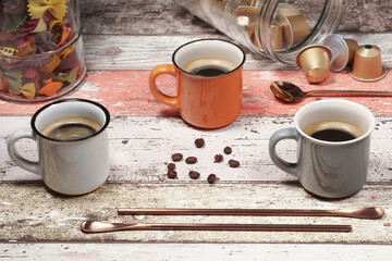 Three colorful cappuccino cups stand on a decorating table