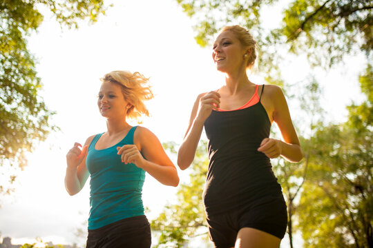 Two women jogging together in park